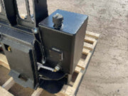Black metal component on a wooden pallet with a concrete floor background