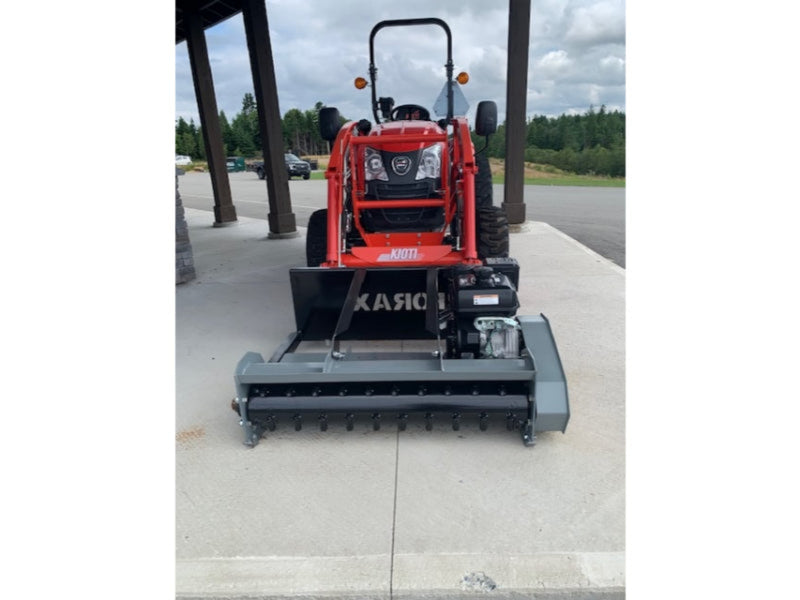 Small red tractor with a attachments on a concrete surface