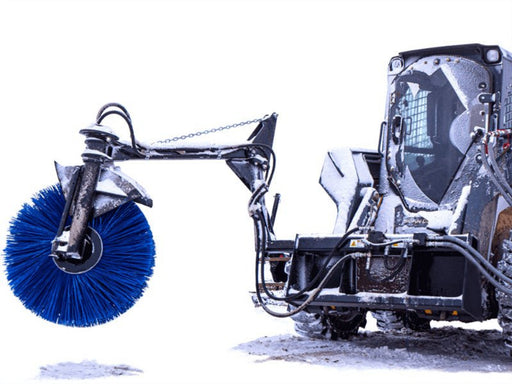 Skid steer operating Maxx Bunk Sweeper attachment to clean feed bunk with blue rotary brush.